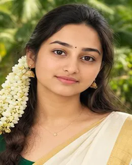 Anjali in a cream kasavu saree and gold jhumkas, a small bindi on her forehead