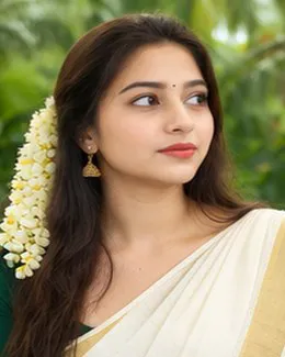 Shruti in a cream saree, her hair loose over one shoulder