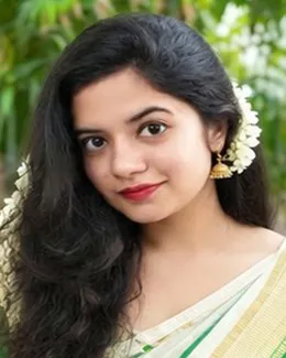 Ananya in a cream saree, jasmine on one side, green leaves behind